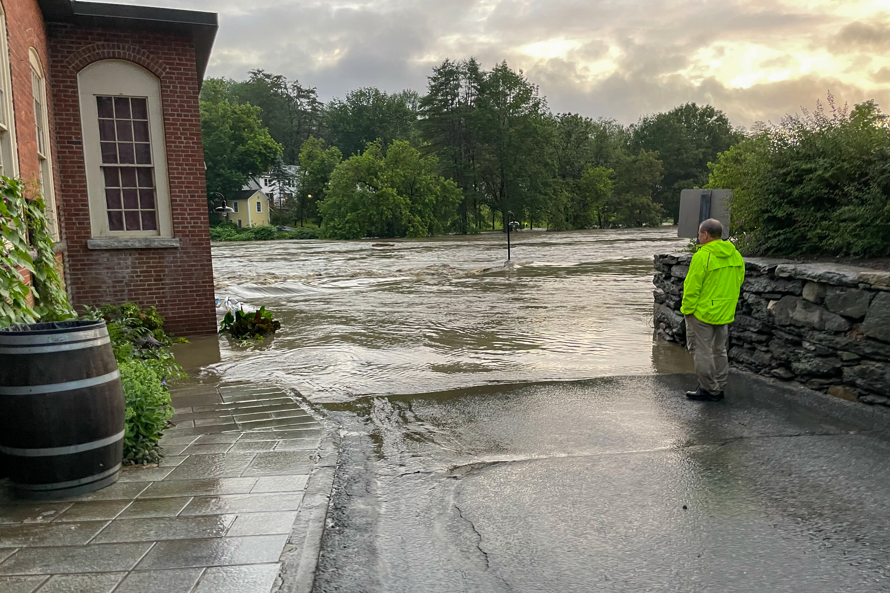 Workers watches flooding of Ottauquechee River